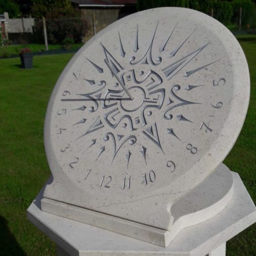Cadran solaire en pierre de Bourgogne. Gravure d’un soleil de style Maya et peinture argenté.