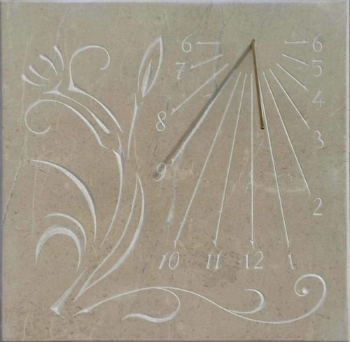 cadran solaire en pierre de Bourgogne avec le motif du fleur et de chiffre arabe.