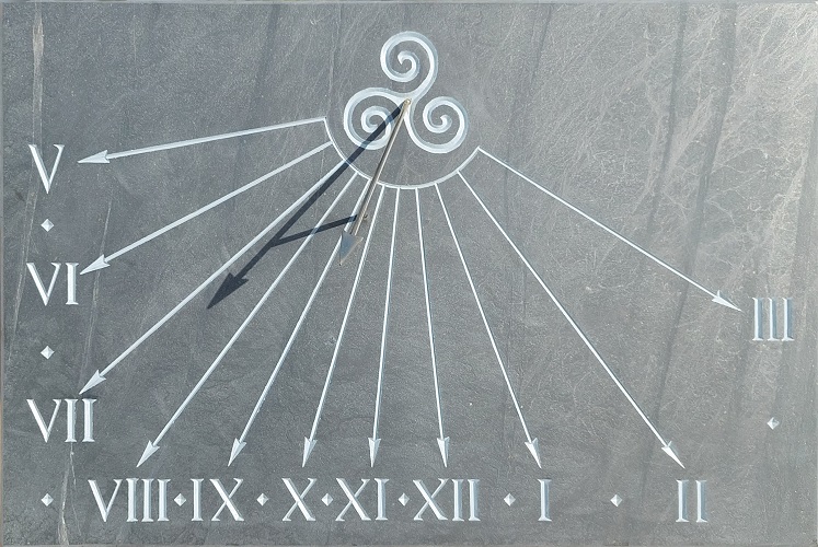 Réalisation d’un cadran solaire en ardoise, avec gravure d’un triskell et de chiffre romain.
